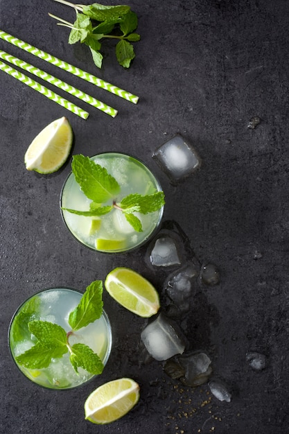 Mojito cocktail in glass with lime and mint on the stone top view