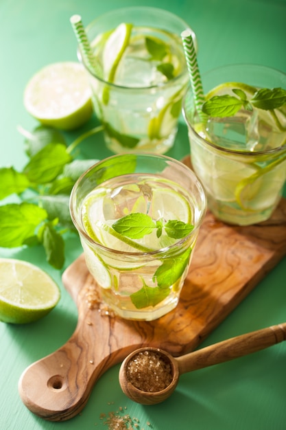 Mojito cocktail and ingredients over green table