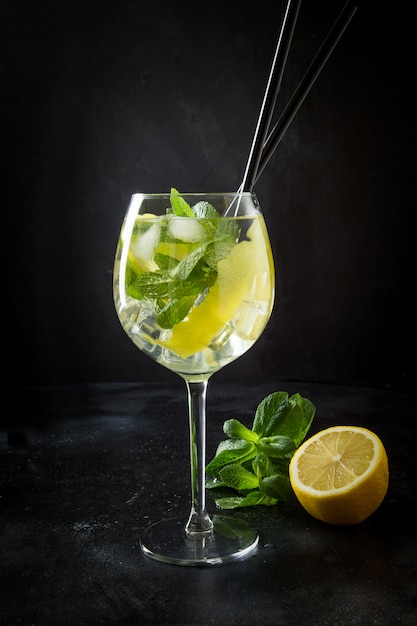 Mojito cocktail or lemonade with mint in glass on black Close up Summer drink