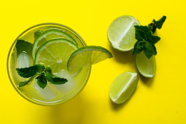 Mojito cocktail on a yellow background Flat lay