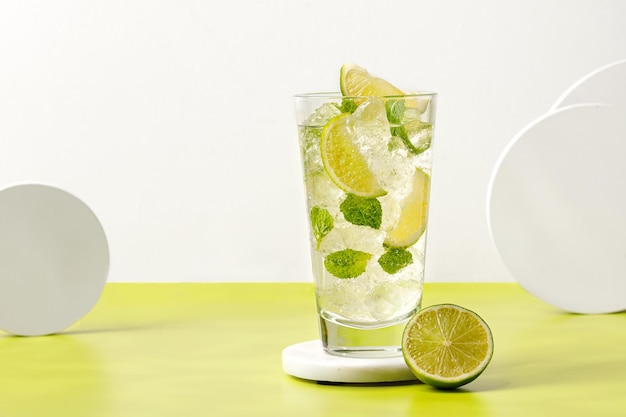 Mojito Ijskoud zomerdrankje Glas koude tonic met limoen op podium Limonade met ijs en munt