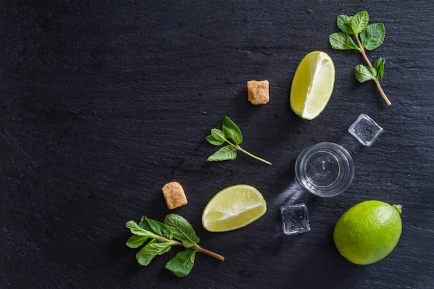 Mojito and ingredients, dark stone background