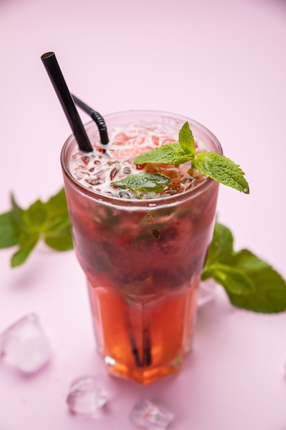 Mojito met aardbeien frambozen en munt op de roze tafel