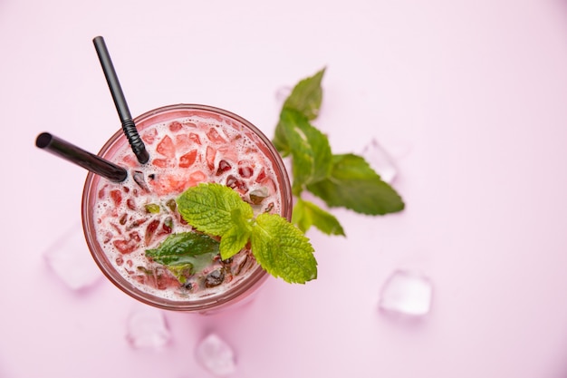 Mojito met aardbeien frambozen en munt op de roze tafel