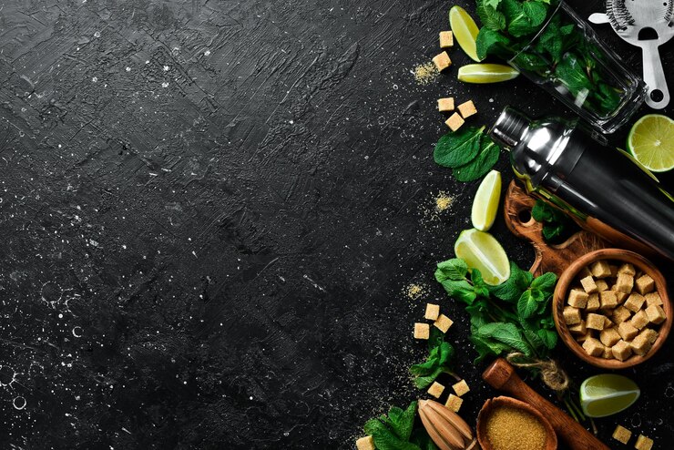 Mojito preparation shaker lime mint and ice On a black stone background Top view