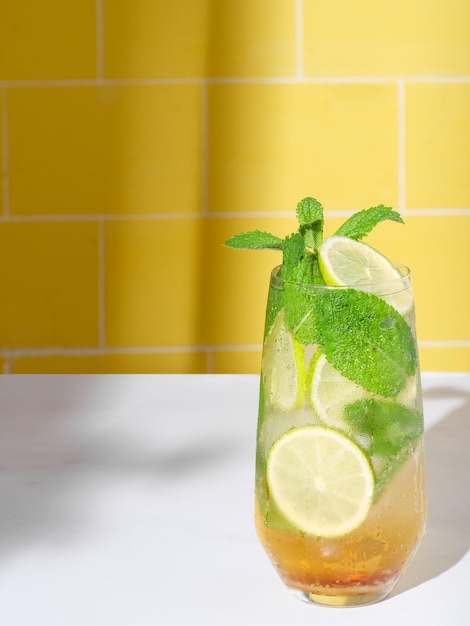 Photo mojito or virgin mojito long rum drink with fresh mint lime juice cane sugar and soda on yellow background