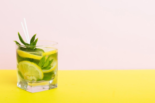 Mojito zomer verfrissende cocktail met ijs en munt Mojito cocktail met limoen, citroen en munt in een hoog glas met een stokje