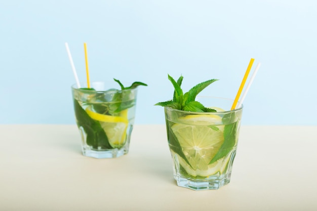 Mojito zomer verfrissende cocktail met ijs en munt Mojito cocktail met limoen, citroen en munt in een hoog glas met een stokje