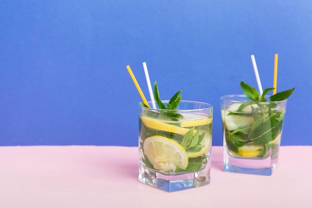 Mojito zomer verfrissende cocktail met ijs en munt Mojito cocktail met limoen, citroen en munt in een hoog glas met een stokje