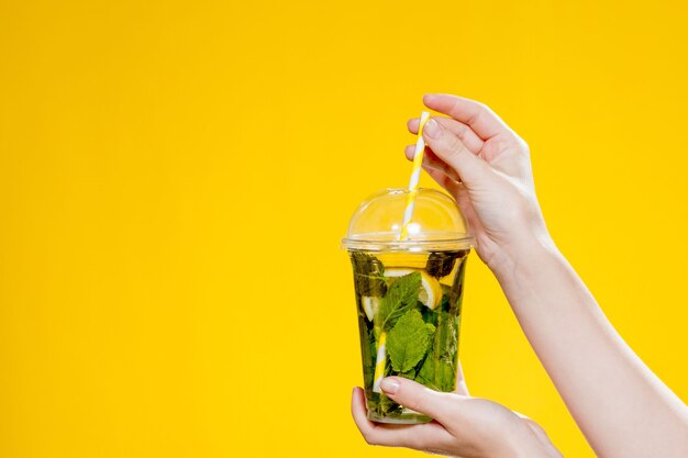 Mojitococktail in een plastic glas met een tube