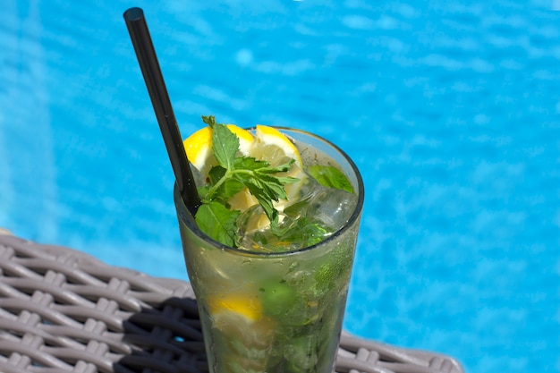 Mojitococktail in glas op de achtergrond van de pool