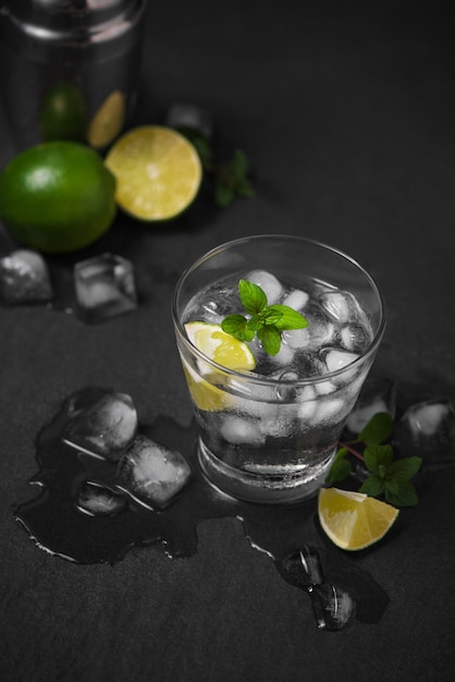 Mojitococktail met limoen en munt in glas op een grijze stenen ondergrond