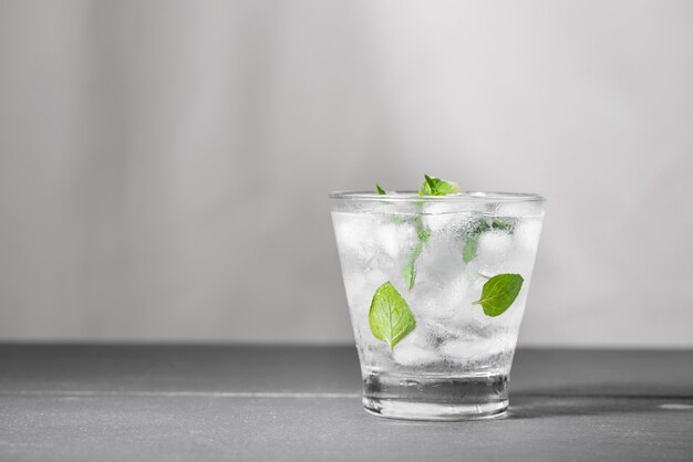 Mojitococktail met limoen en munt in glas op een grijze stenen ondergrond