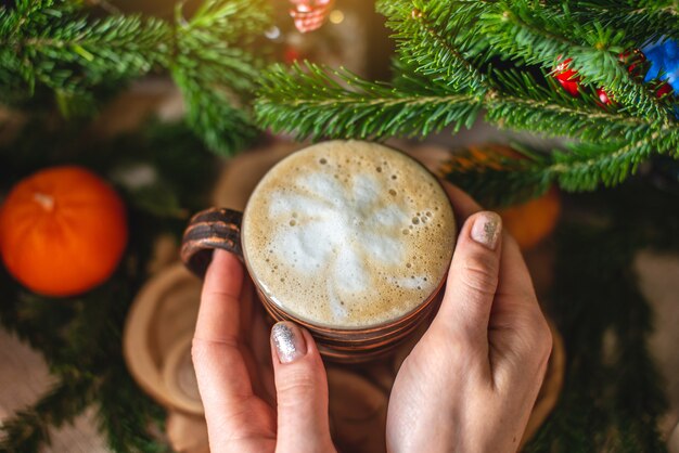 Mok cappuccino koffie met groene takken van een kerstboom