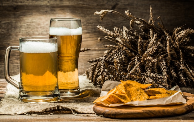 Mok, glas bier op houten tafel met tarwe aartjes