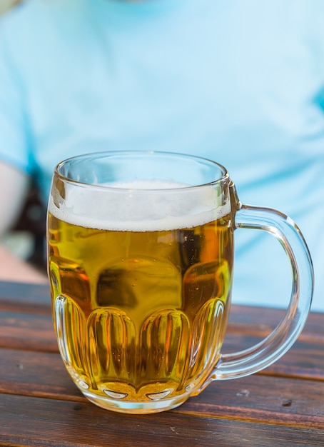 Mok licht bier staat op een houten tafel in een taverne