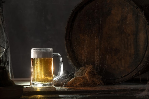 Mok met vers licht bier met schuim op houten vintage achtergrond met vatÑŽ Oude wijnkelder of pub