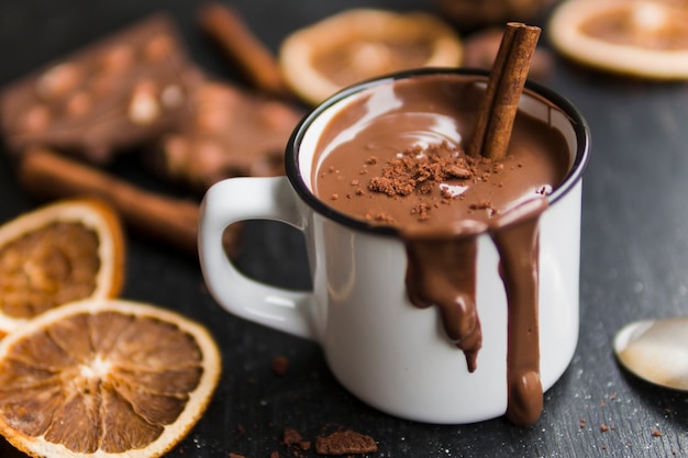 Mok van chocolade met druppels op houten tafel