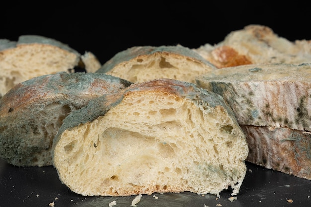 Mold on bread on a black background closeup The danger of mold stale products