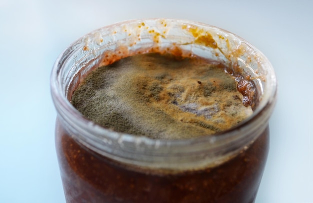 Foto muffa su marmellata di lamponi alimenti avariati vaso di muffa violazione della tecnologia di cottura cibi in scatola pericolo per la salute