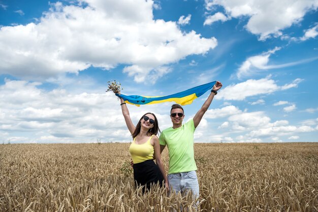 Molda happy couple with flag of ukraine in wheat field. lifestyle