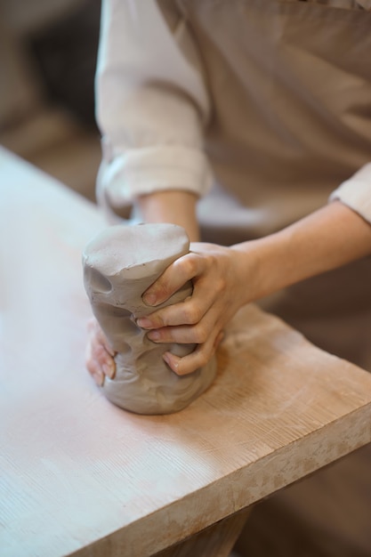 Molding. Close up of female hands molding the shape of a pot