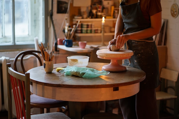 Лепка и скульптура на гончарном круге женщина-мастер в художественной студии лепит кувшин из сырой глины