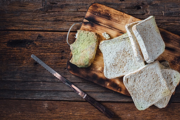 Moldy bread on wooden table