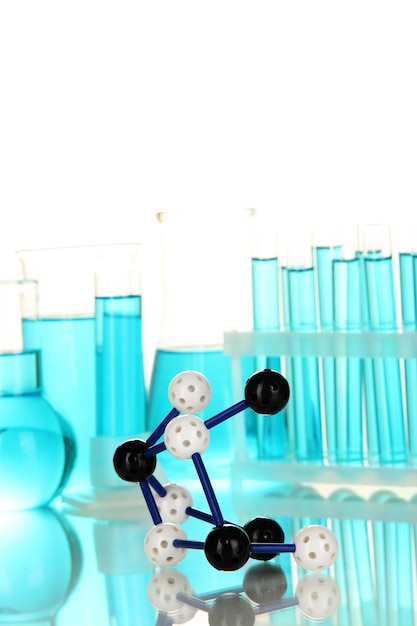 Фото Модель молекулы и пробирки с голубыми жидкостями, изолированными на белом