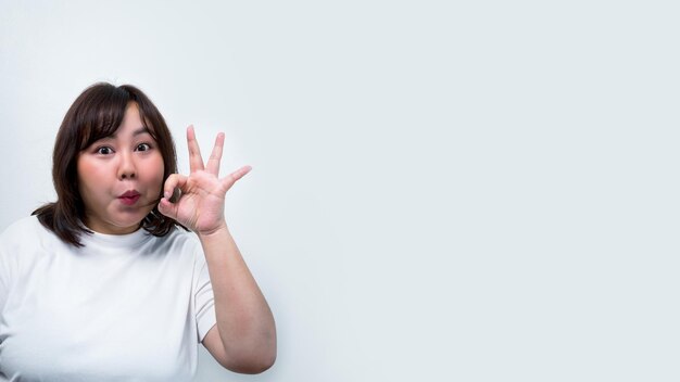 Foto mollige aziatische vrouw toon verschillende gebaren met gezichtsuitdrukkingen en met de hand wijzen vertegenwoordigt een symbool van communicatie op een witte achtergrond voor kopieerruimte