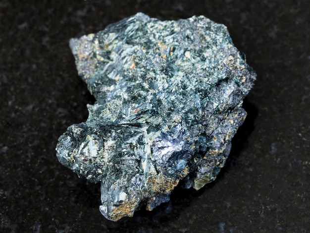 Photo molybdenite crystal in rough glaucophane on dark