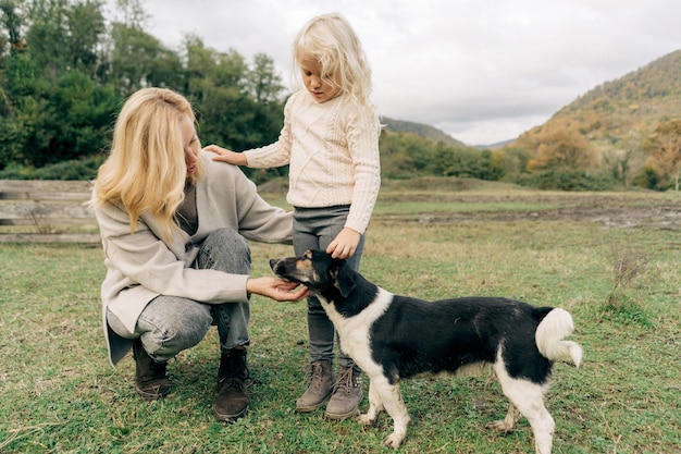 사진 엄마와 딸은 시골에서 개를 산책시니다.