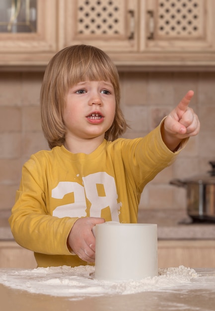 写真 ママと彼女の小さな子供は台所で料理をしています。