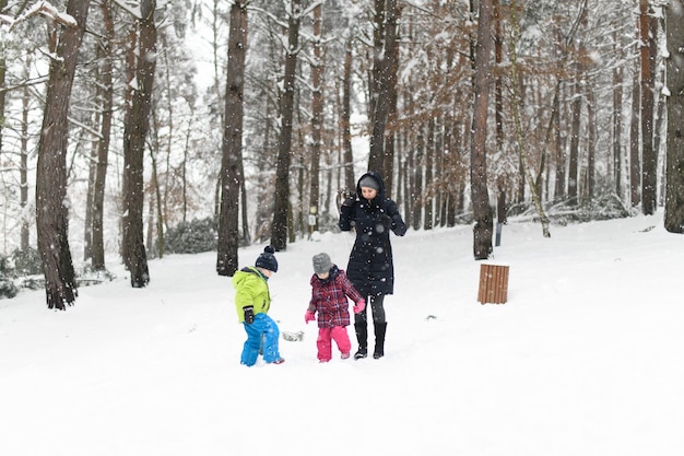 写真 お母さんと 2 人の子供がそり遊びを終えました