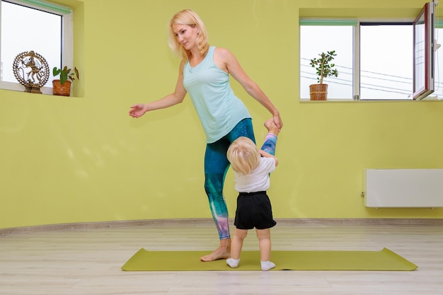 Mom and baby are doing yoga in the hall