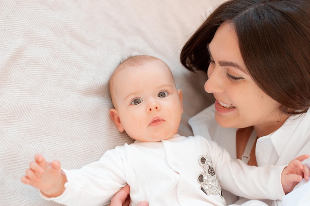 Mom and baby are lying on the bed in the bedroom