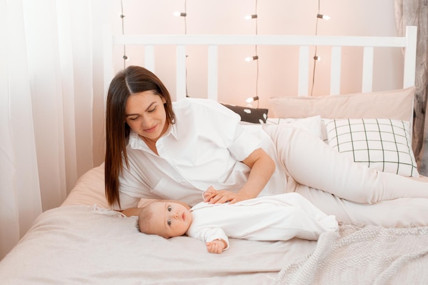 Mom and baby are lying on the bed in the bedroom