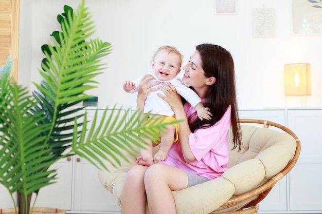 Mamma e bambino sorridono nel soggiorno di casa per la cura del bambino maternità