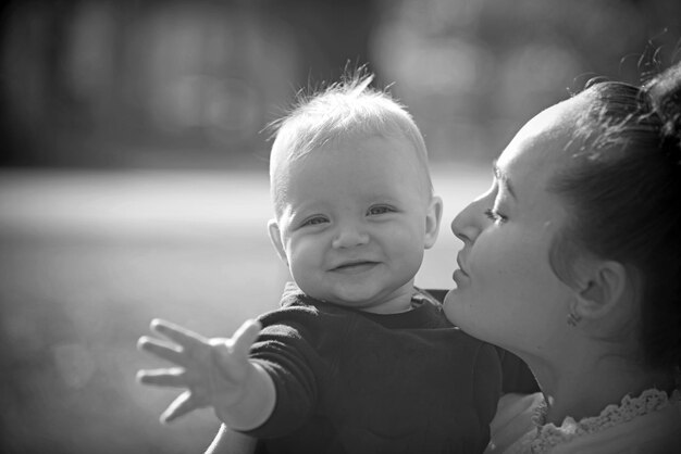 Mamma e bambino all'aperto madre abbraccia il figlio piccolo con amore donna con bambino concetto di festa della mamma la famiglia felice si gode la giornata di sole amore, cura e fiducia