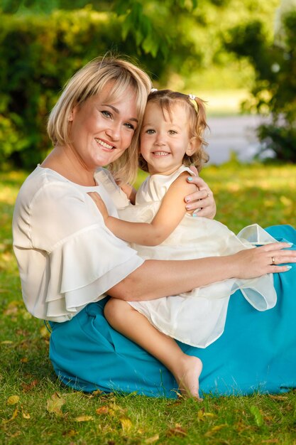 Mom blonde with daughter in the park in summer in sunny weather