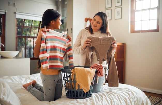 Mom child and fold laundry in bedroom for hygiene home cleaning and clean clothes lifestyle in home Family mother and daughter helping happiness conversation and relax working together on bed