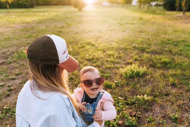 Mom the child is playing in the park the child is wearing mom's sunglasses