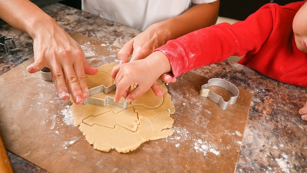 Mom and child make a mold for New Year's cookies. 