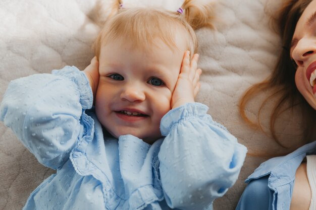 Mom and child play and have fun on the bed. mothers Day.