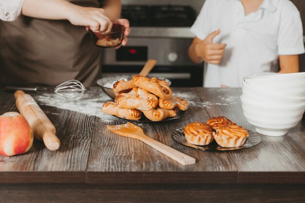 ママと子供が母の日のキッチンでバースデーケーキを準備します。これは、実際の生活からインテリアの日常生活を描いた一連の写真です。