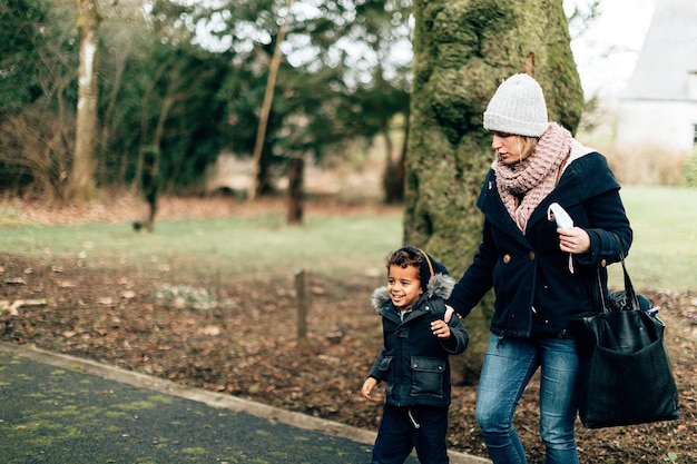 Mom and child walking in a park together on a cold winter day stock photo