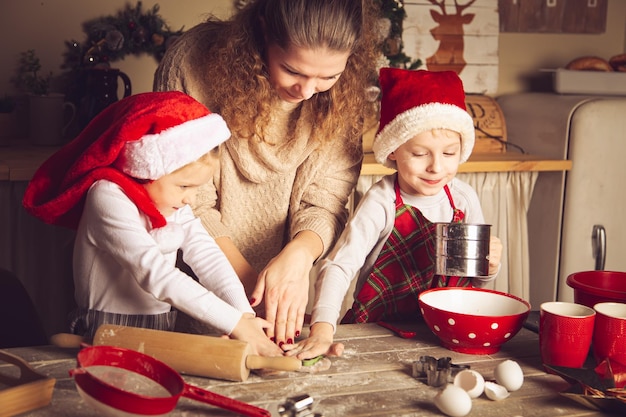 Mom and children are preparing cookies in the kitchen