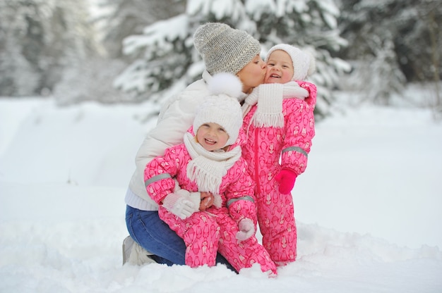 Mom and children on a walk in the winter in the forest.