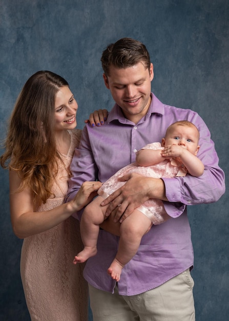 Mom and dad are holding a newborn baby in their arms Young family and baby