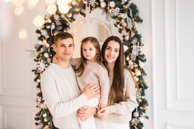 Mom, Dad and daughter at Christmas. Portrait of a family on a New Year's background